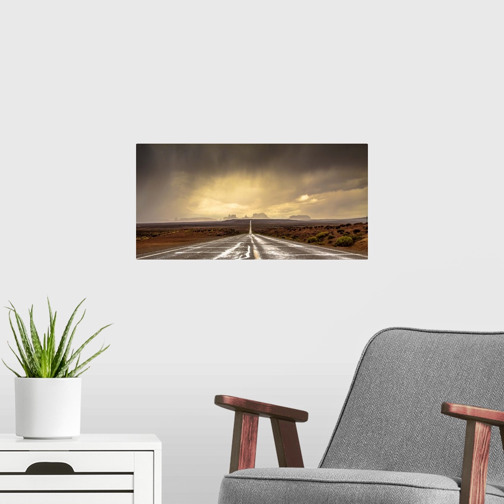 A modern room featuring Road leading towards the rock formations in Monument Valley under a stormy sky.