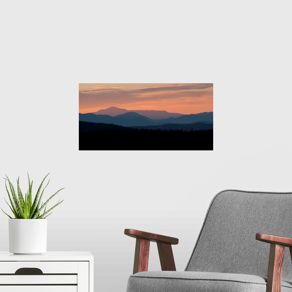 A modern room featuring Landscape photograph of a silhouetted mountain range at sunset.