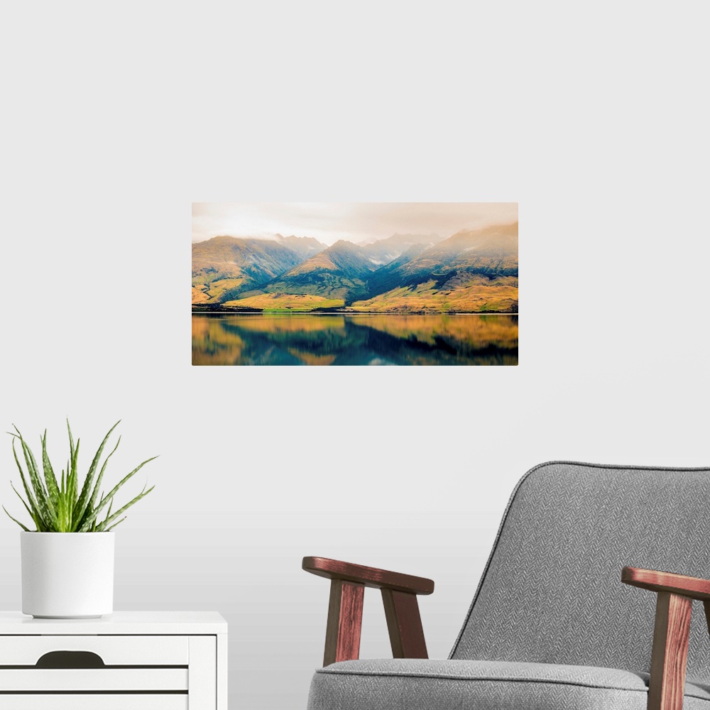 A modern room featuring Landscape photograph of a lake with Autumn covered mountains in the background and a foggy top.