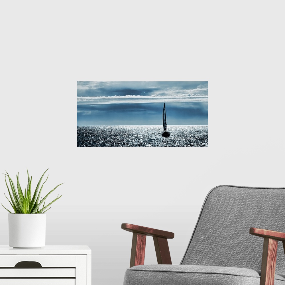 A modern room featuring Silhouettes of a yacht sailing alone in the ocean to the horizon.
