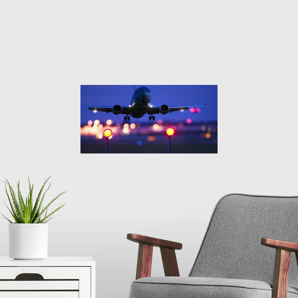 A modern room featuring Composite close-up of an airplane landing with blurred lights of the airport in the background