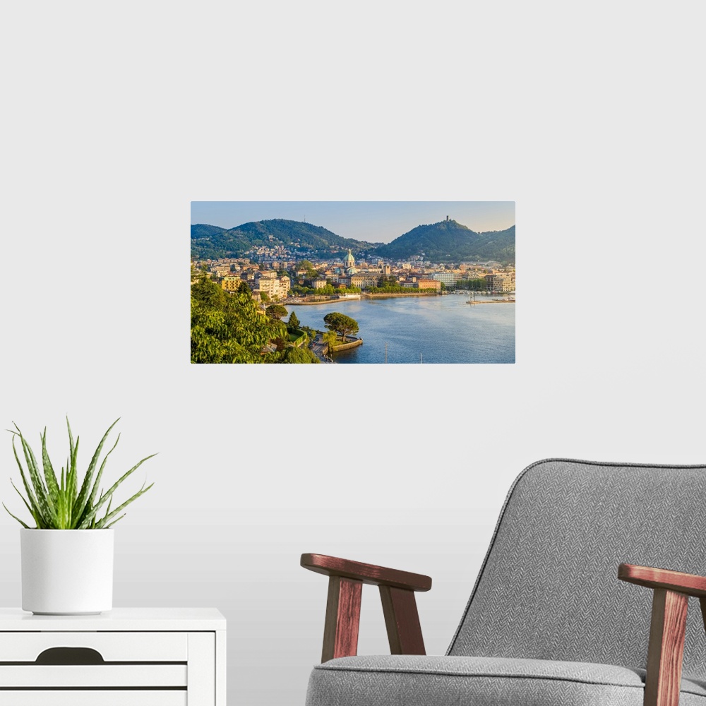 A modern room featuring Como, Lombardy, Italy. High angle view cityscape of Como and the lake front, with the Cathedral o...