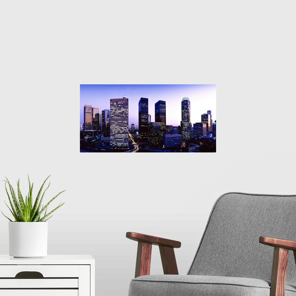 A modern room featuring Panoramic photograph of cityscape at sunset with buildings lit up.