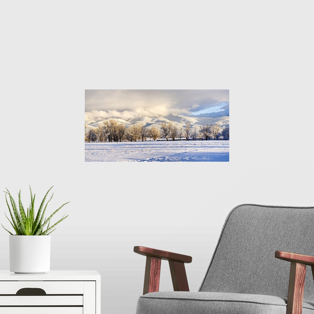 A modern room featuring Pasture land covered in snow with Taos Mountain in the background, Sangre De Cristo Range, San Lu...