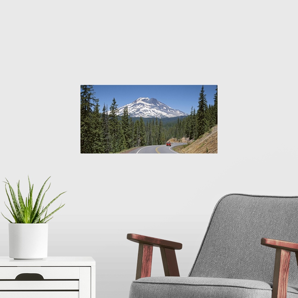 A modern room featuring Vehicle moving on a road with South Sister Mountain in background, Oregon
