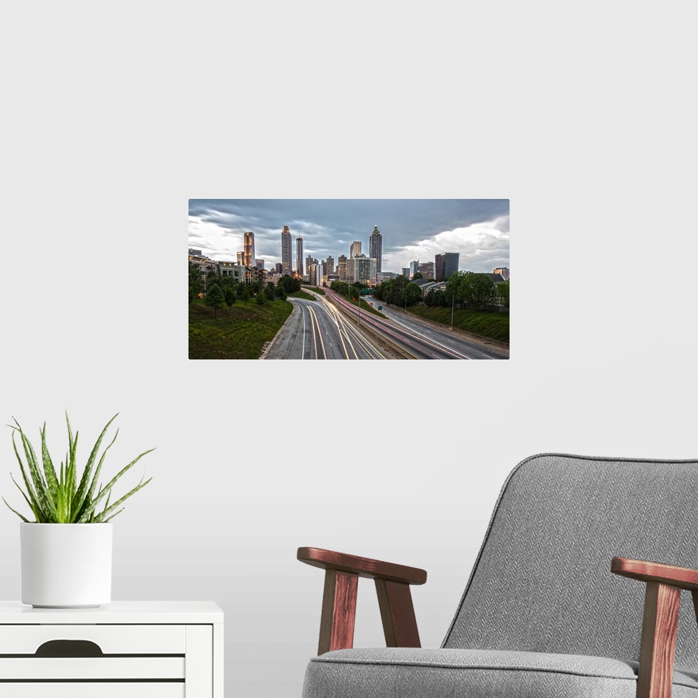 A modern room featuring Skyscrapers in the Atlanta, Georgia skyline and light trails from passing cars on the roads in th...