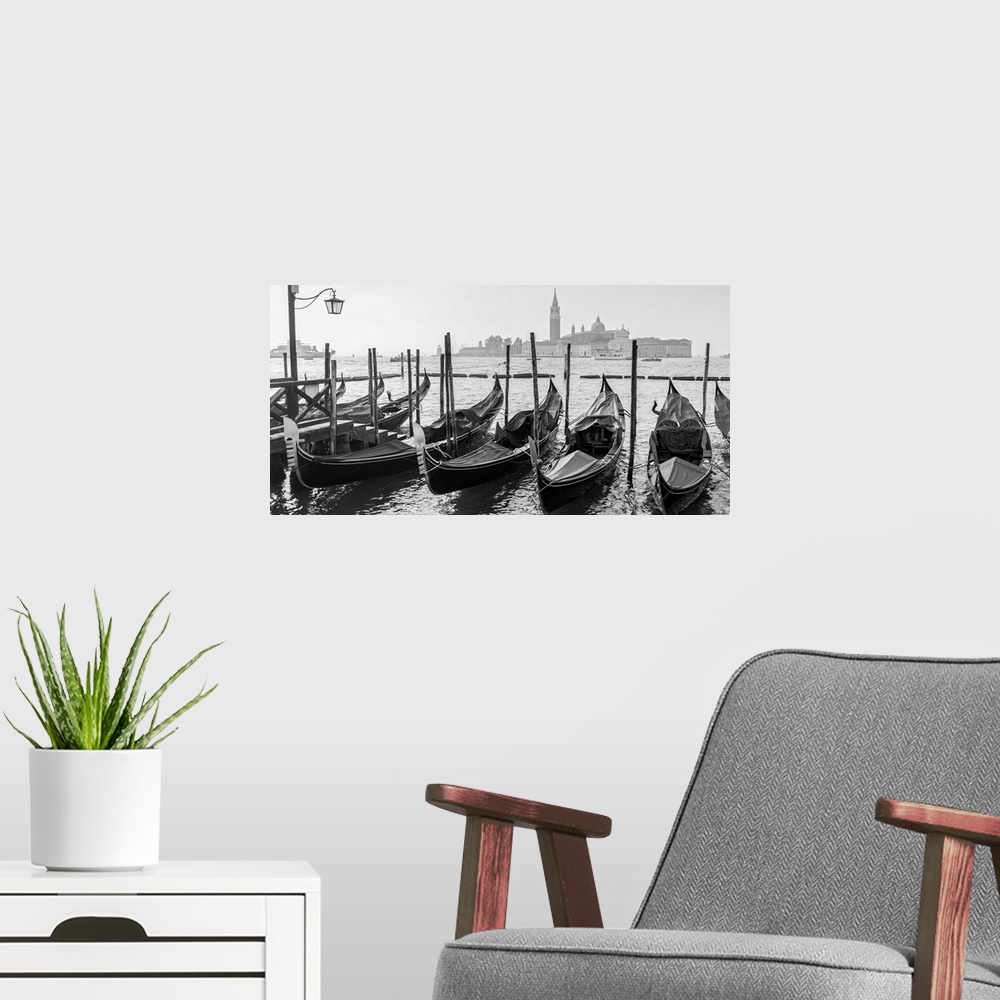 A modern room featuring Black and white photograph of a row of gondolas in front of Piazza San Marco (St. Mark's Square) ...