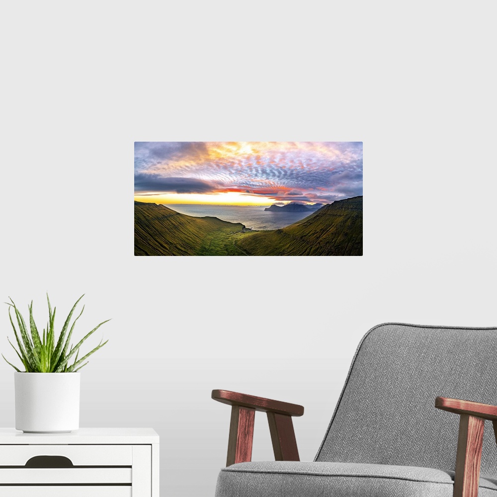 A modern room featuring Dramatic sky with clouds at sunrise over the coastal village of Gjogv, aerial view, Eysturoy Isla...