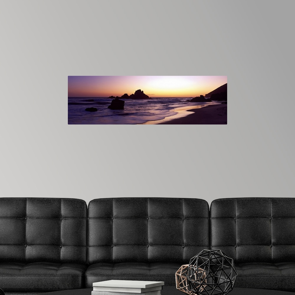 A modern room featuring Sunset panoramic of the rocky beach in California.