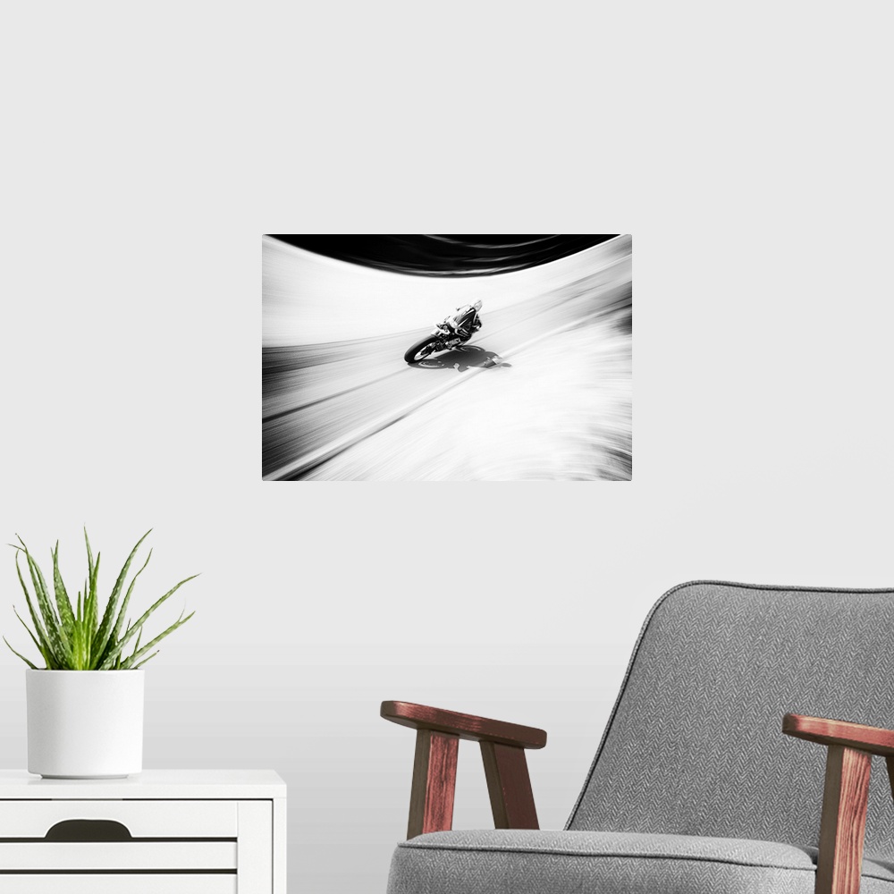 A modern room featuring A figure on a motorcycle traveling fast on a curved road.