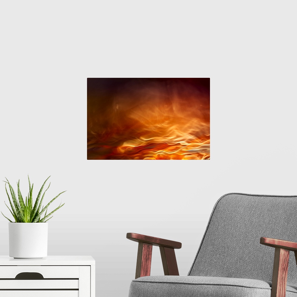 A modern room featuring Abstract digital art with orange, yellow, and red hues resembling water on fire.