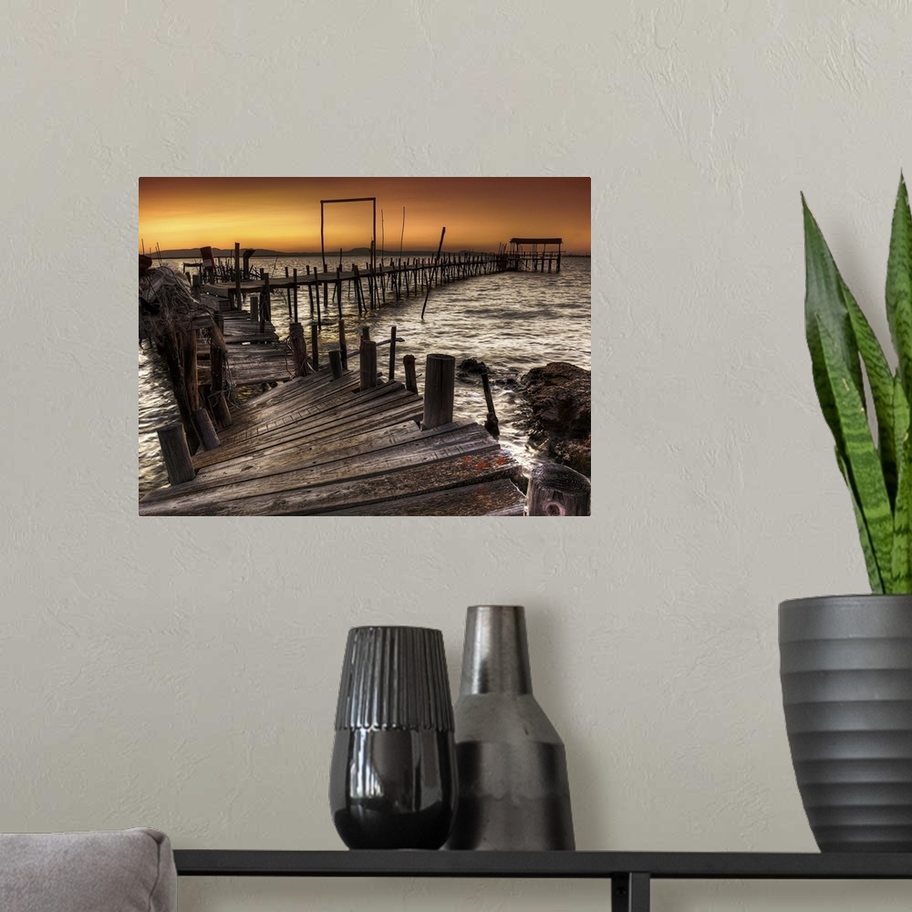 A modern room featuring A decaying wooden pier in Carrasqueira, Spain, at sunset.