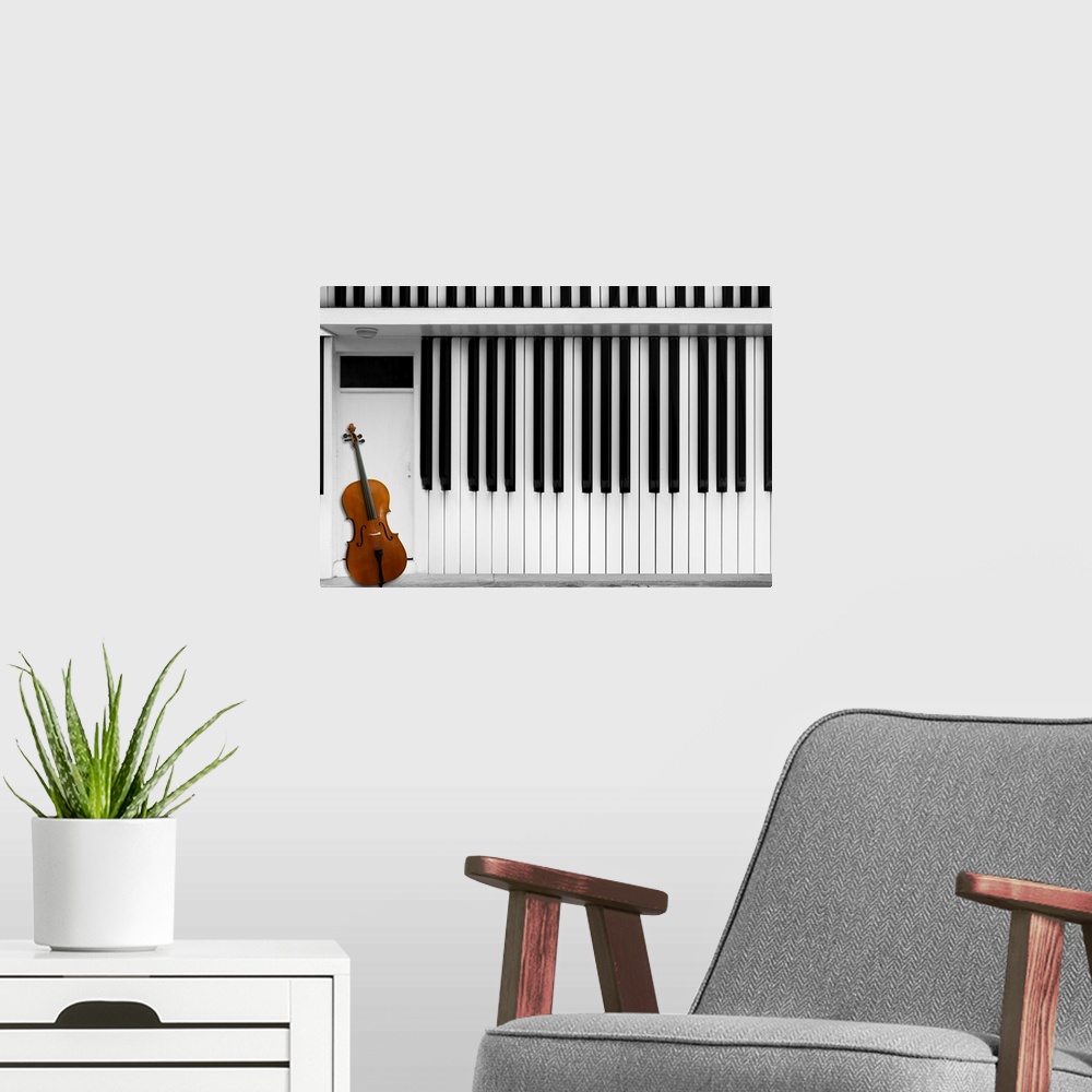 A modern room featuring A cello resting against a house made of piano keys.