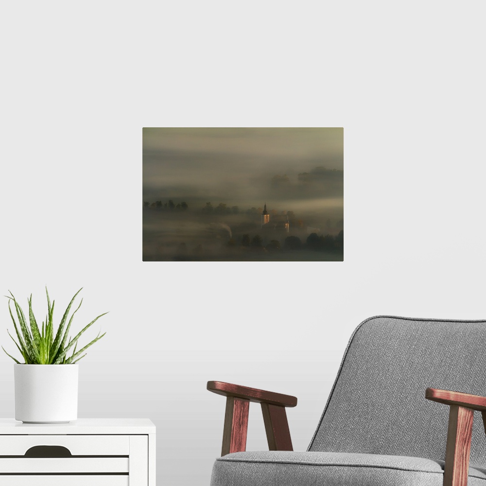 A modern room featuring Church spire rising through the thick blanket of fog that covers this countryside scene.