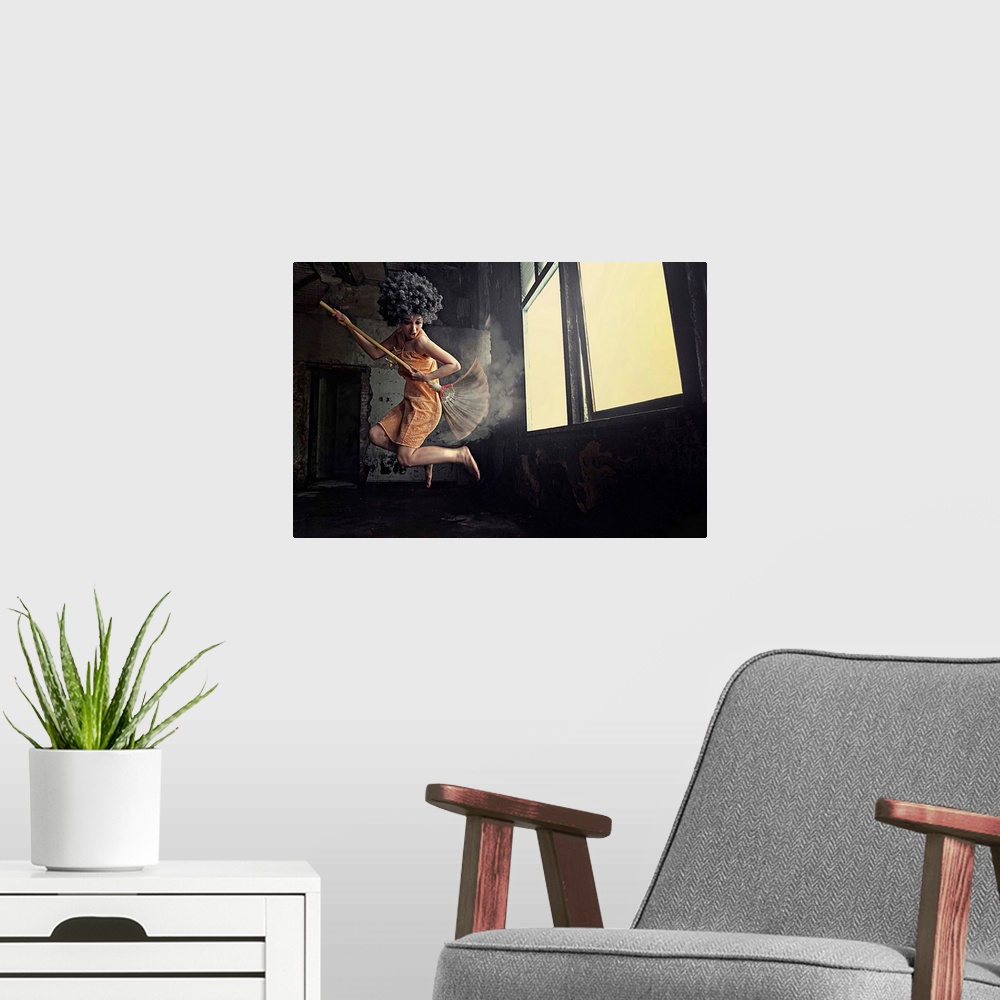 A modern room featuring A women leaping into the air playing air guitar on a mop in front of a window.
