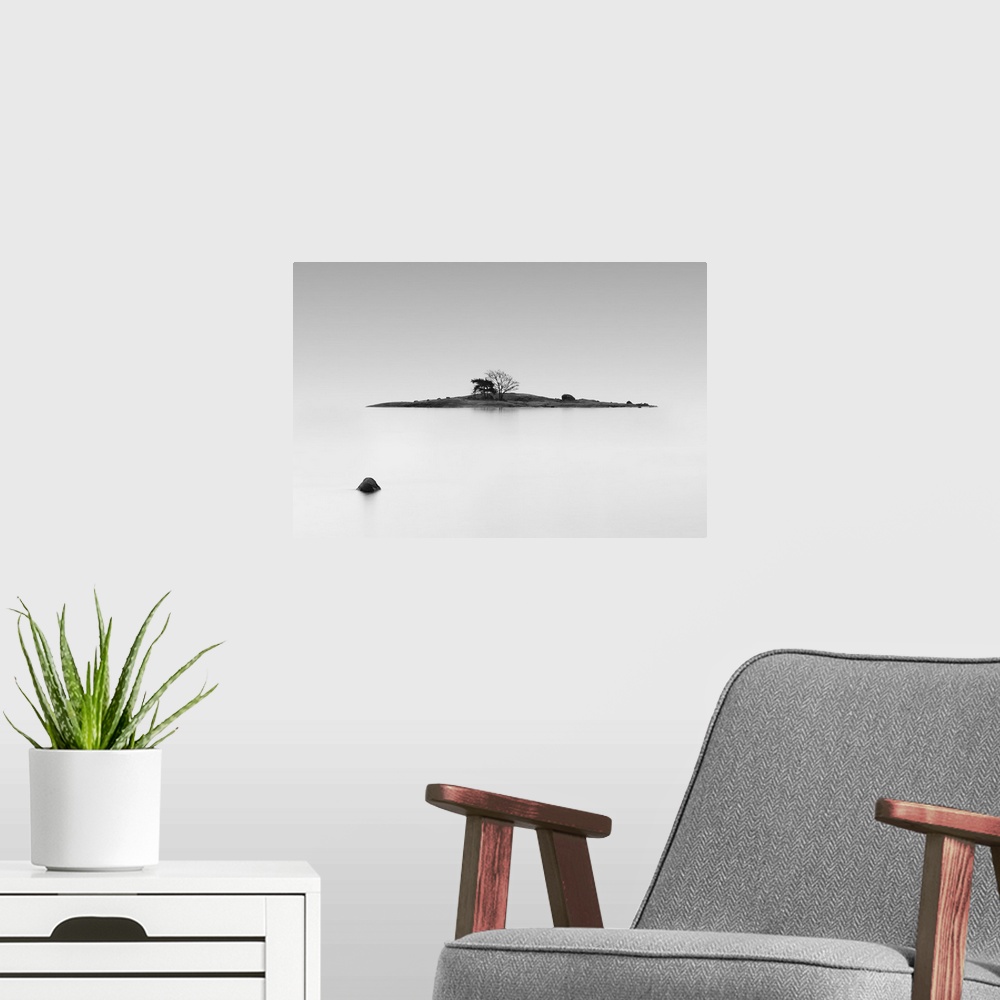 A modern room featuring Black and white photo of a small island in the middle of still water, Finland.
