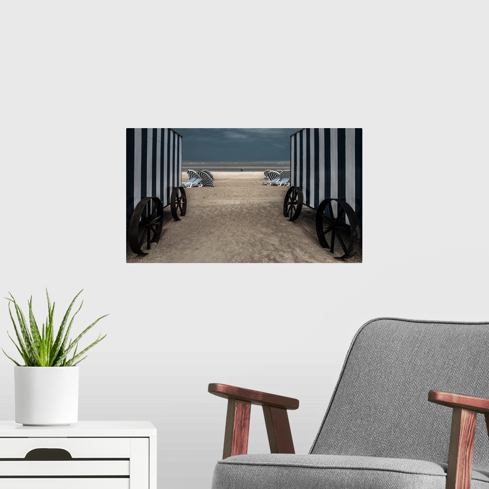 A modern room featuring Looking through two beach changing huts down to the beach.