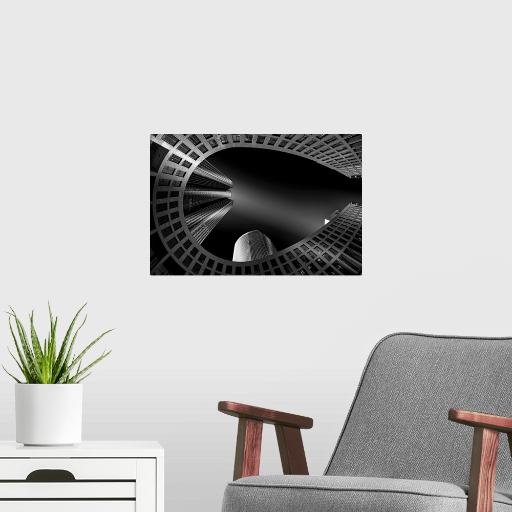 A modern room featuring Black and white architectural abstract photograph of a horseshoe building with other buildings sh...