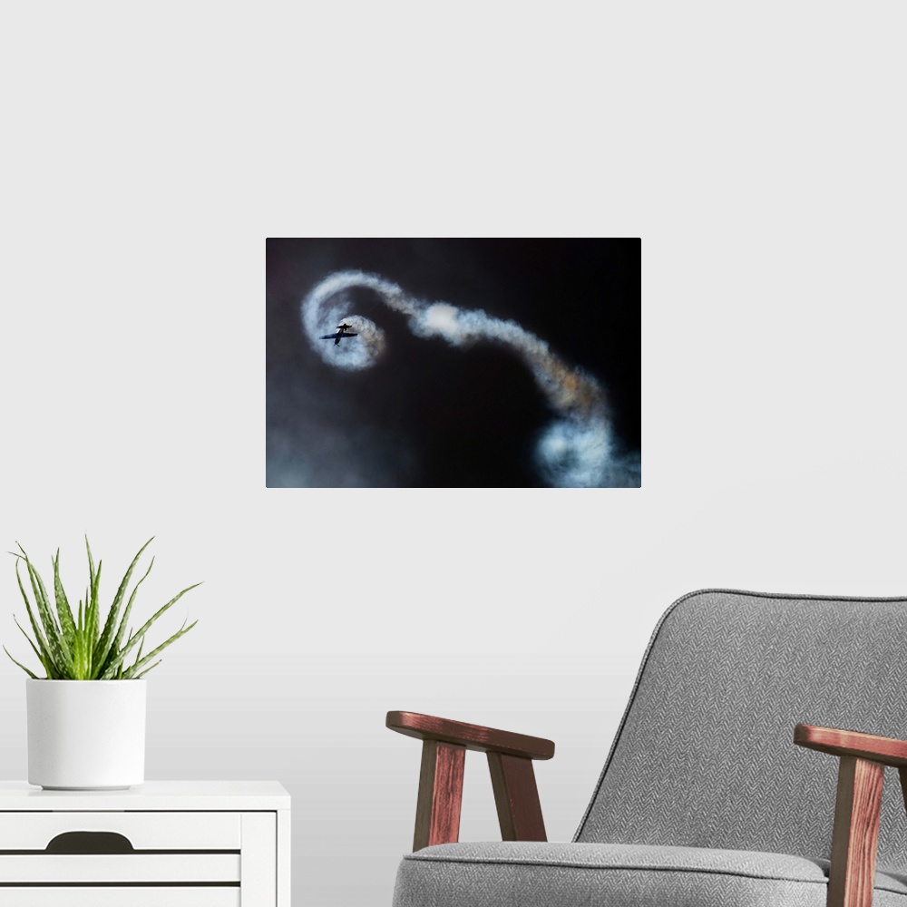 A modern room featuring An airplane leaves spiraling contrails, showing the loops it has just made.