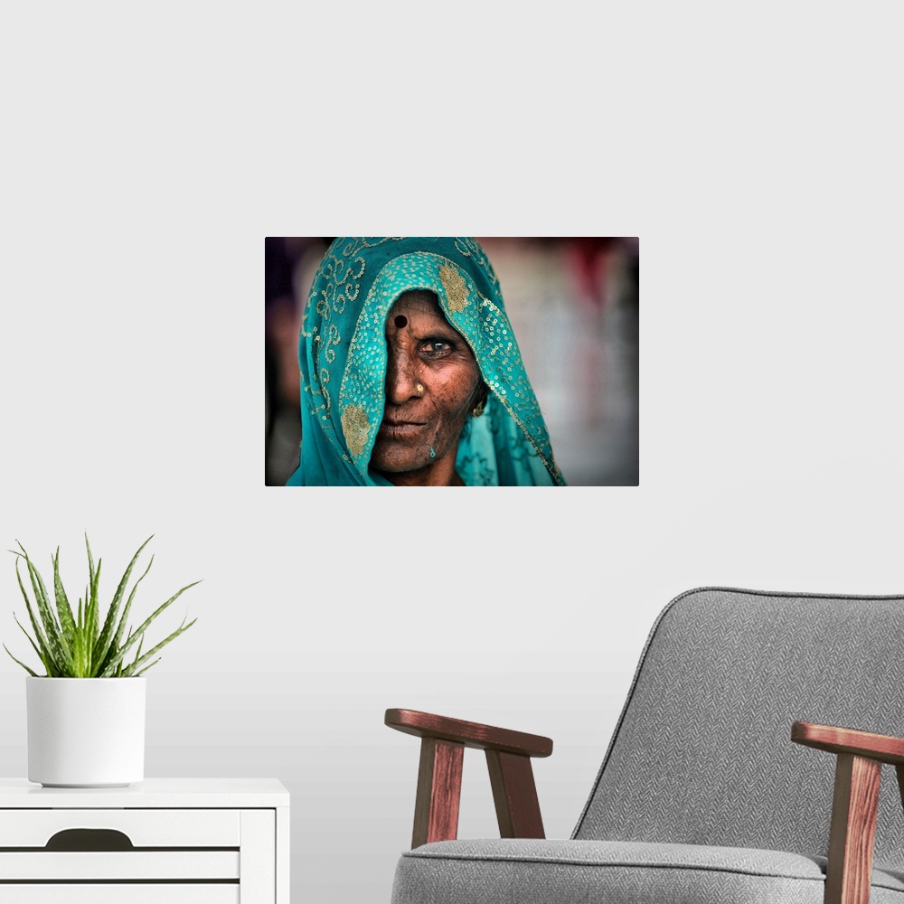 A modern room featuring Portrait of an elderly woman wearing a turquoise embroidered veil.