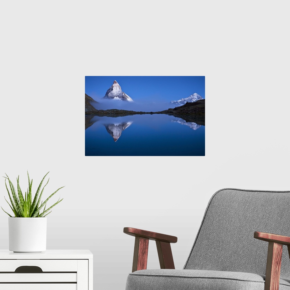 A modern room featuring A photograph of the Swiss Alps with the base of the Matterhorn covered in fog.