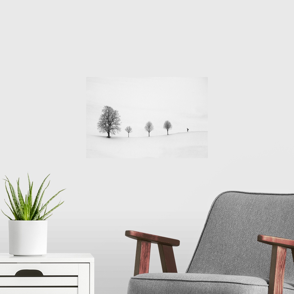 A modern room featuring Minimalist image of a row of three small trees with one larger tree and a skier.