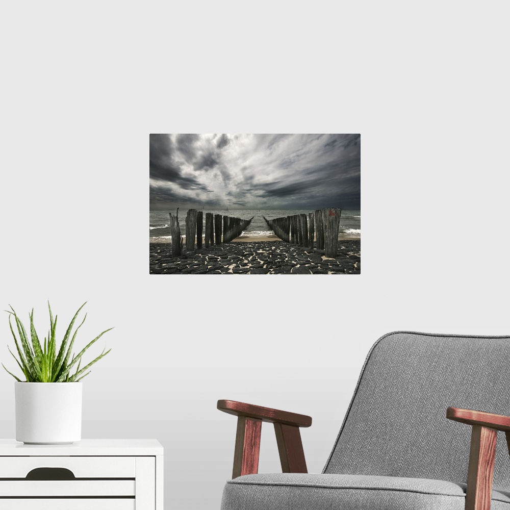 A modern room featuring Landscape photograph of the ocean and the remains of a pier on an overcast, gloomy day.