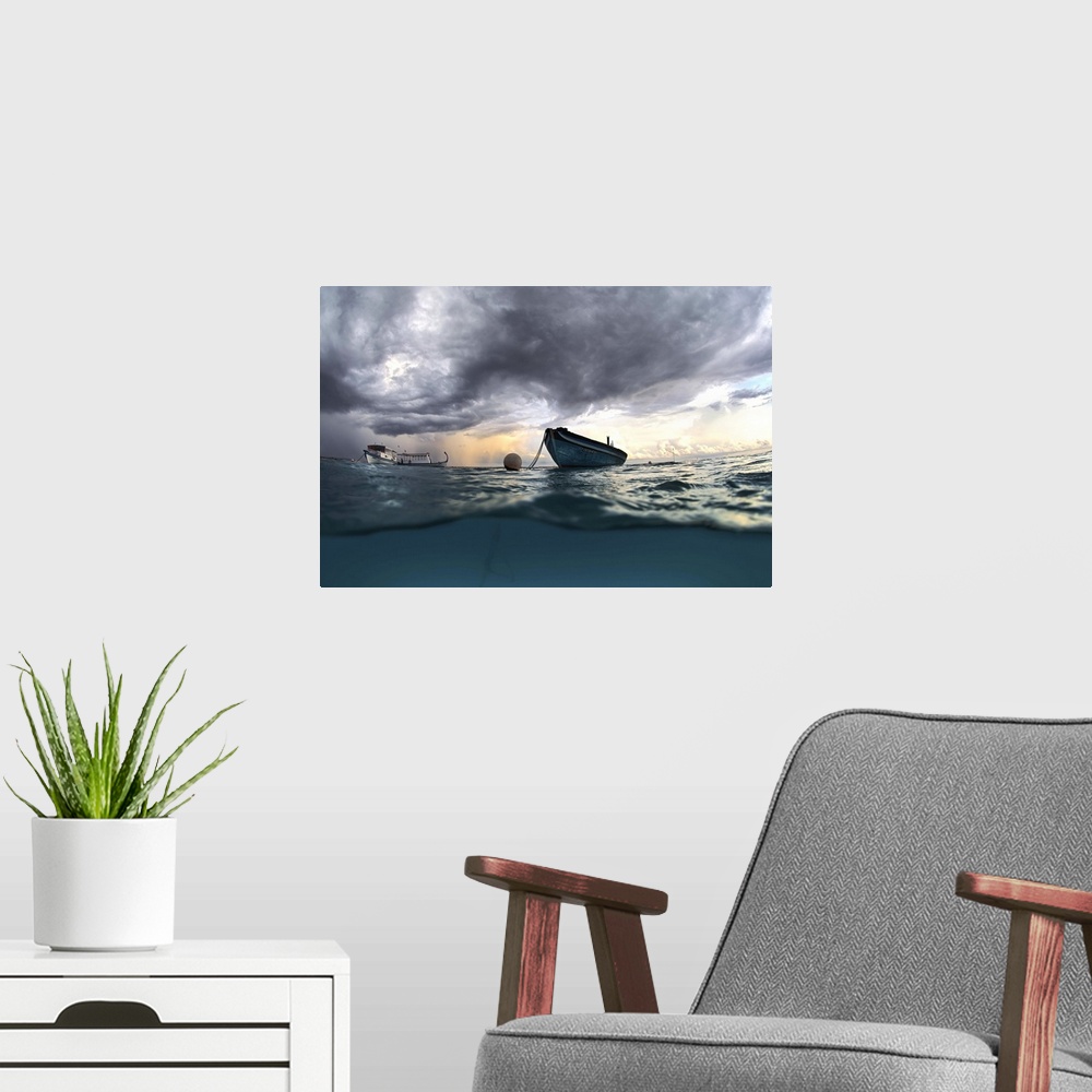 A modern room featuring View from the surface of the ocean of a boat at sea with dark clouds in the sky.