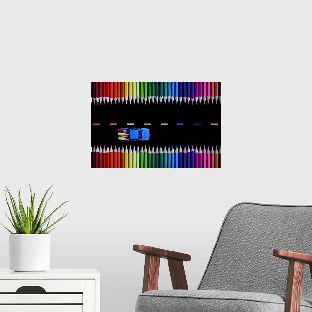 A modern room featuring Conceptual photograph of a two truck hauling tiny colored pencils like lumber along a colored pen...