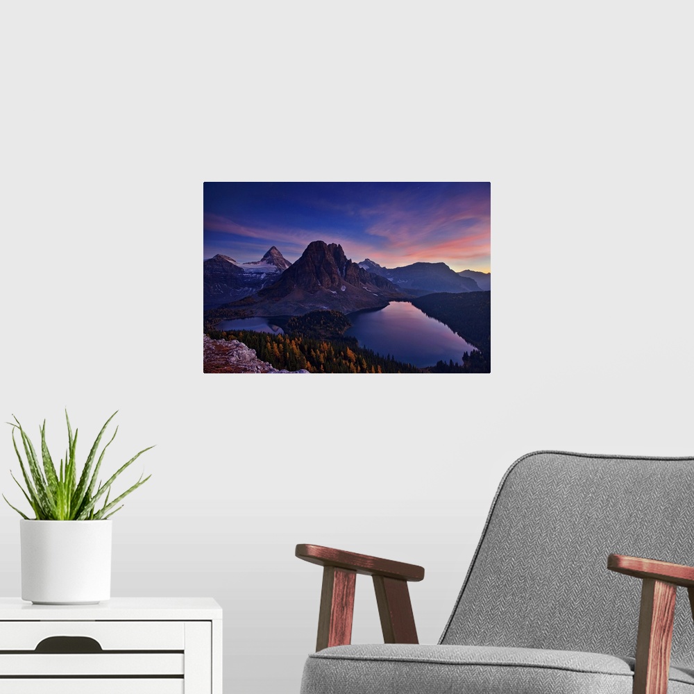 A modern room featuring View of two lakes and a snowy mountain range at sunset, with a pastel sky.
