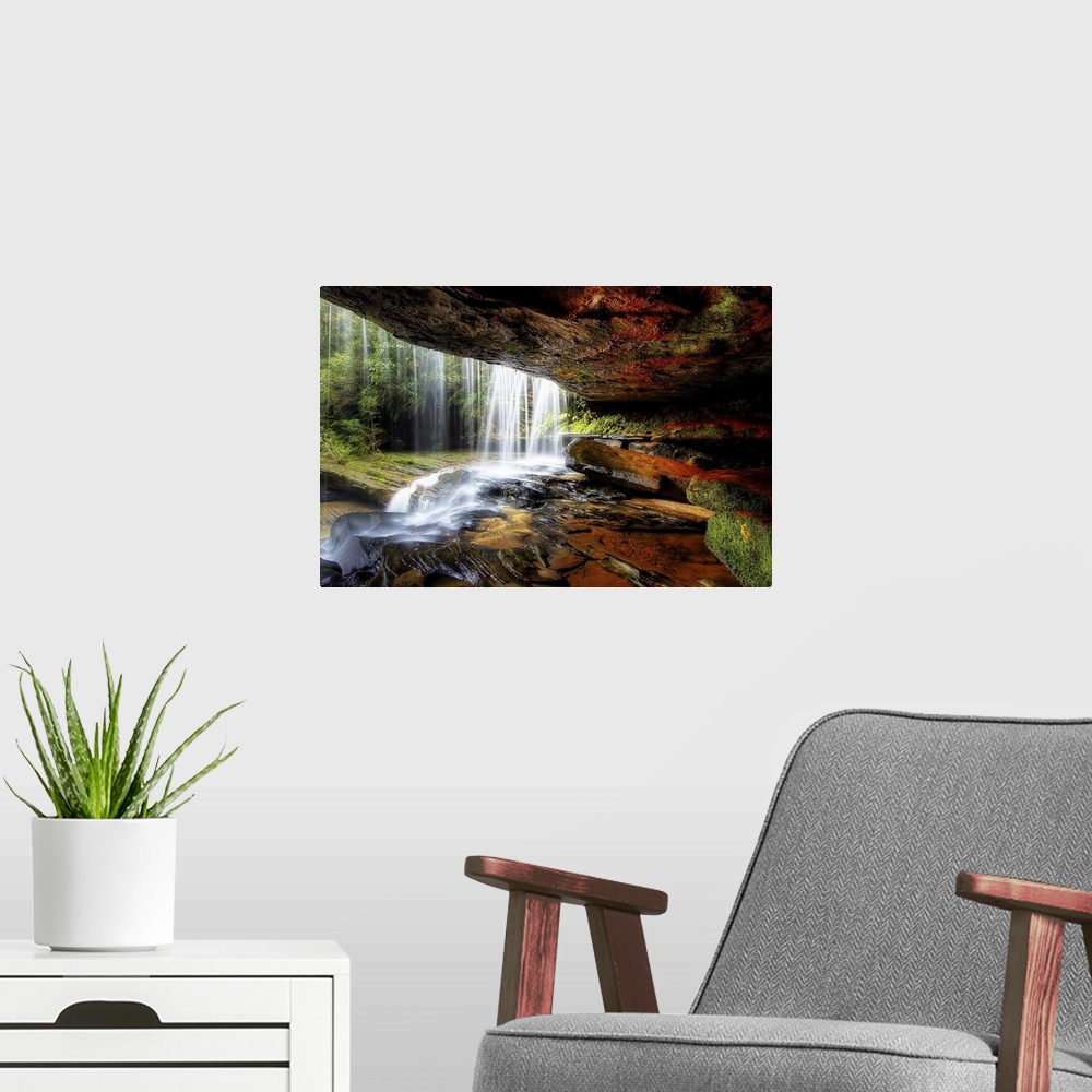 A modern room featuring A cave behind a waterfall with wet stones and moss.