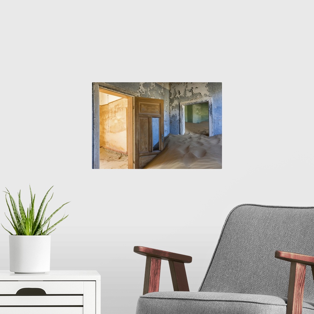 A modern room featuring Photograph of an abandoned home interior now filled with the desert sand.