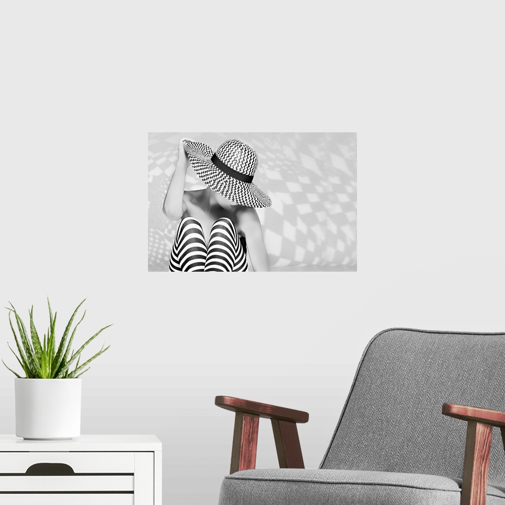 A modern room featuring Black and white portrait of a woman wearing a patterned hat and striped tights.