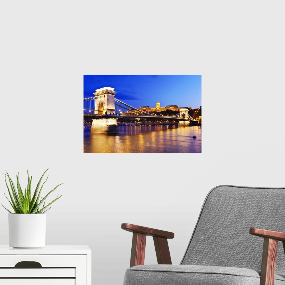 A modern room featuring A view of the Chain Bridge over the river Danube at night.