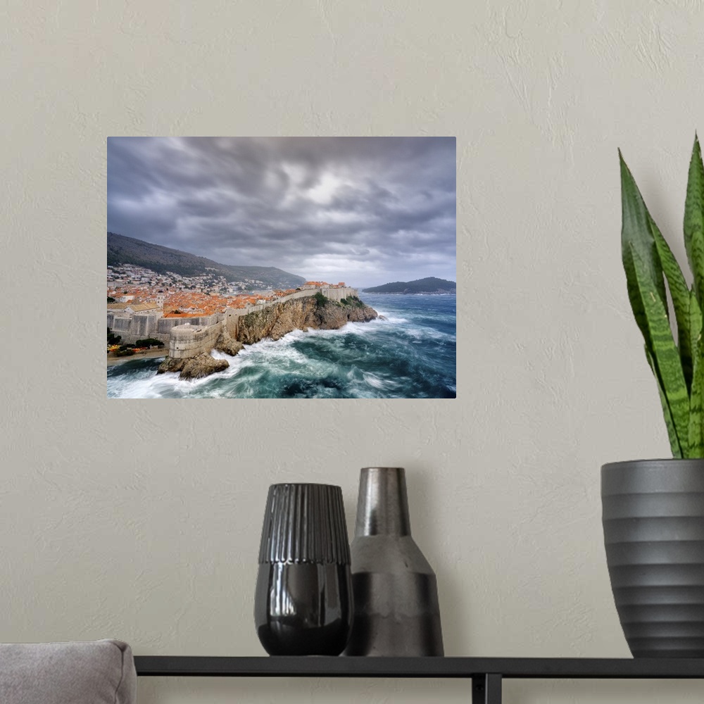 A modern room featuring A view towards Dubrovnik Old Town with stormy seas below the city walls.