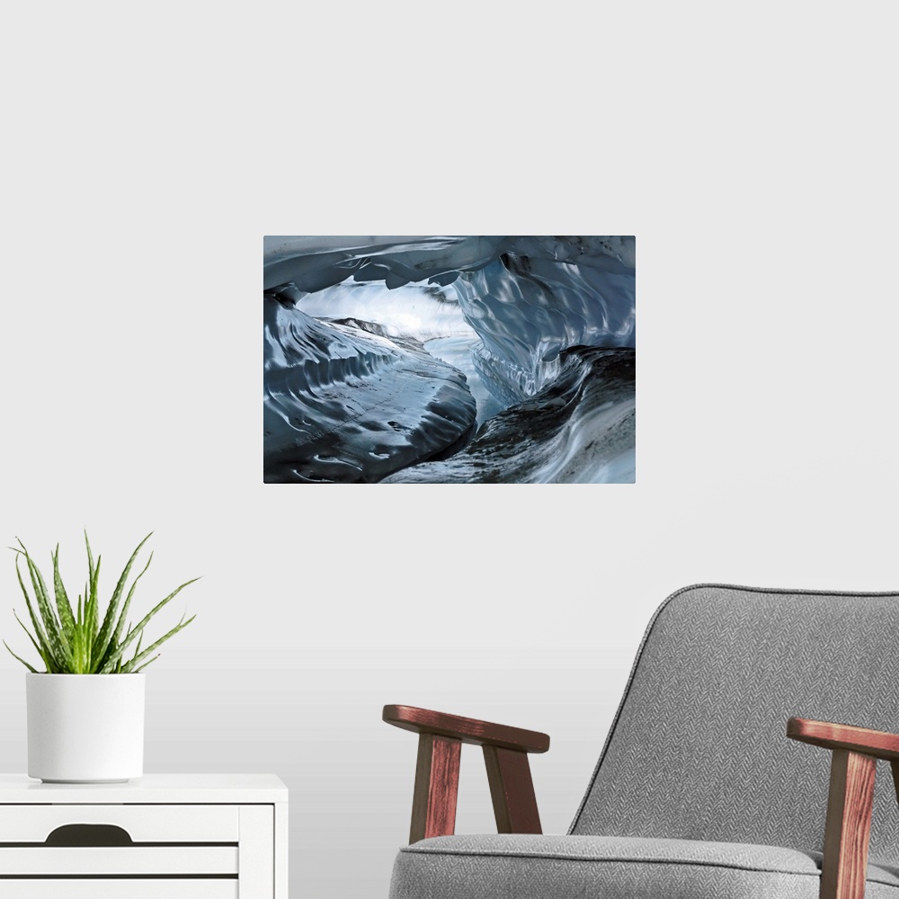 A modern room featuring A photograph inside a tunnel that was formed by a water channel inside a glacier.