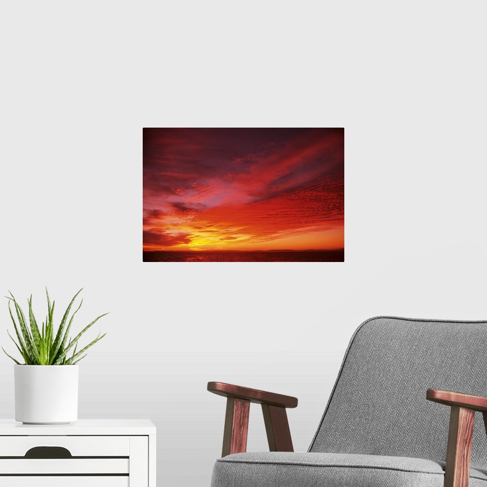 A modern room featuring Bright Orange Sunset Over Ocean
