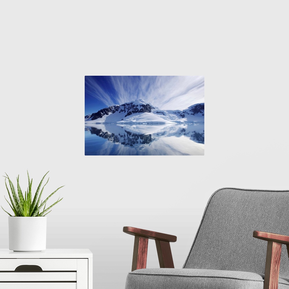A modern room featuring Cirrus clouds over mountainous coast, and reflection in water.