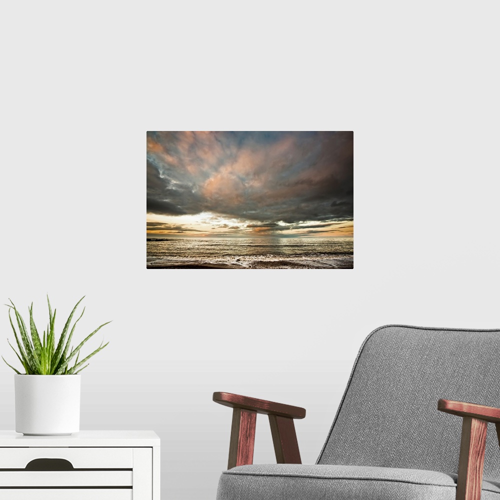 A modern room featuring Dramatic clouds at sunset over the water. South Shields, Tyne and Wear, England.