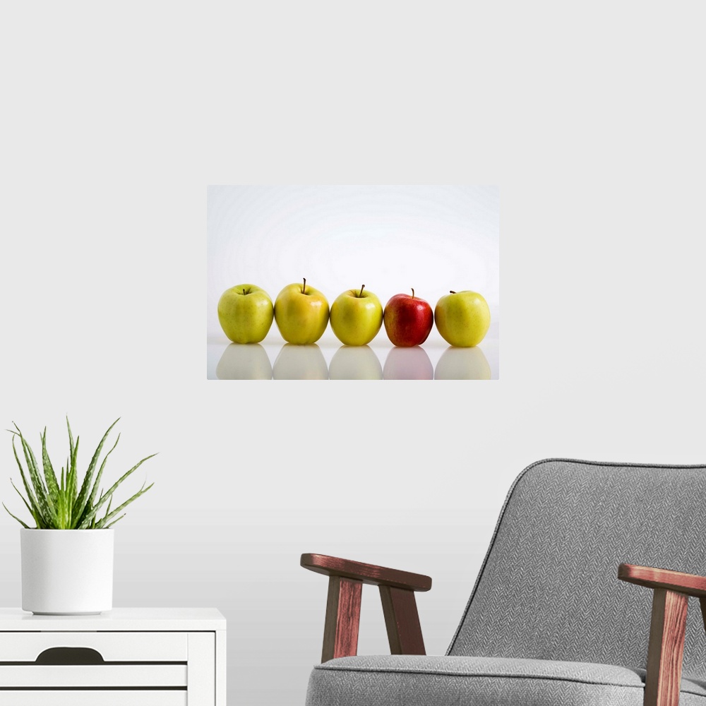 A modern room featuring Four Yellow Apples With One Red Apple In A Row