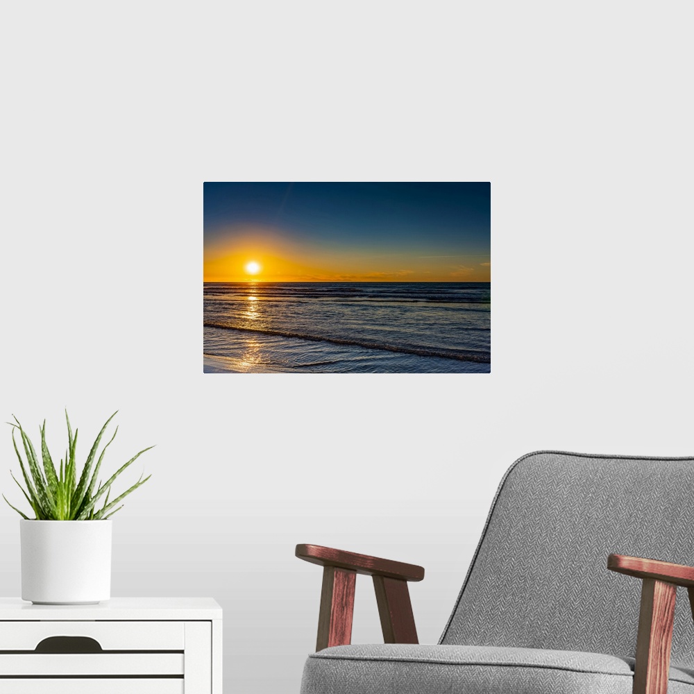 A modern room featuring Golden sunset over the Pacific ocean, viewed from the North shore; New Zealand