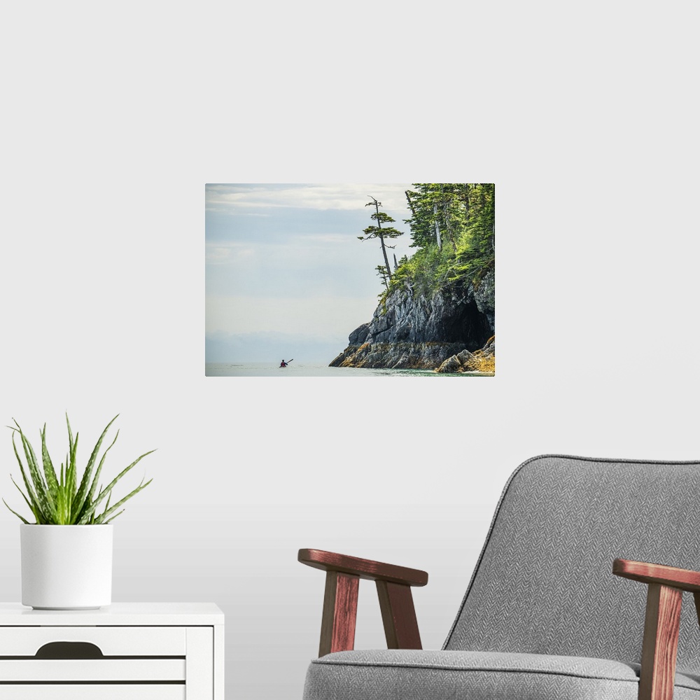 A modern room featuring Kayaker paddling through the calm waters in the beautiful scenery of Prince William Sound; Alaska...