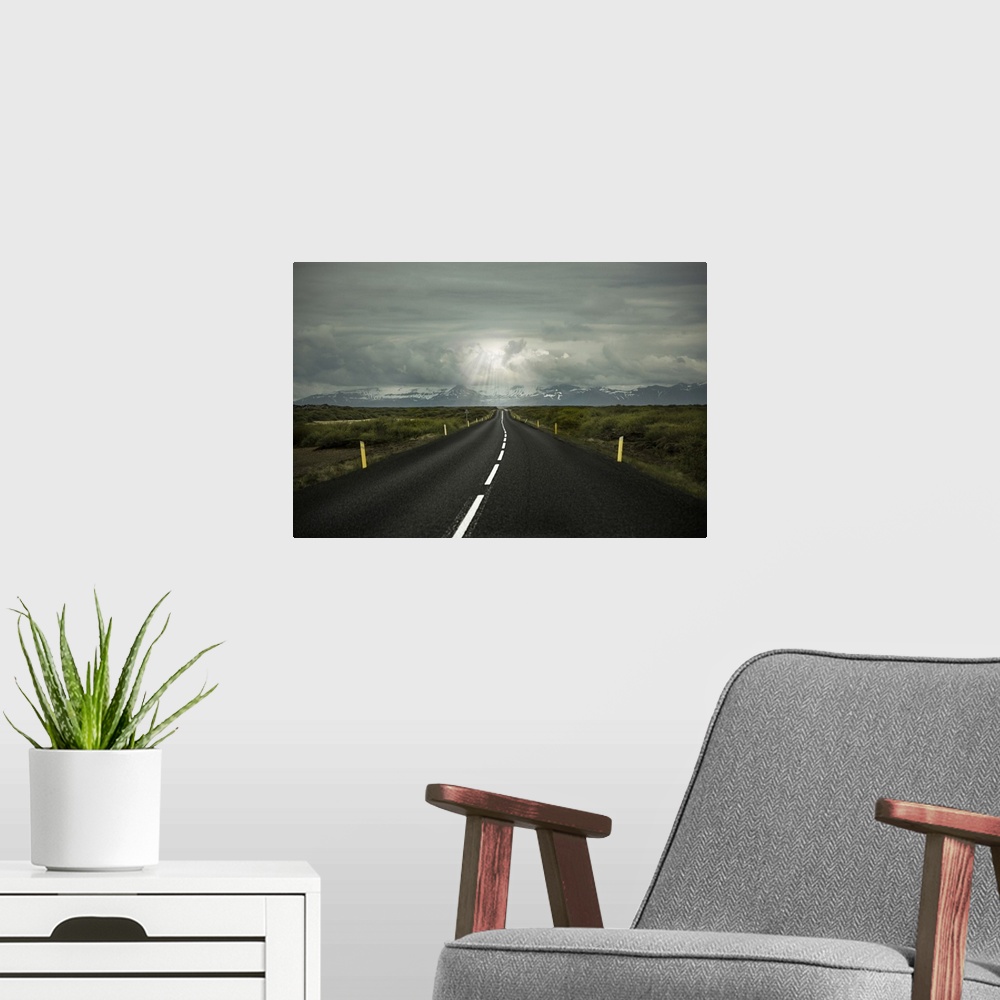 A modern room featuring Long straight empty road leading to mountains in Iceland.