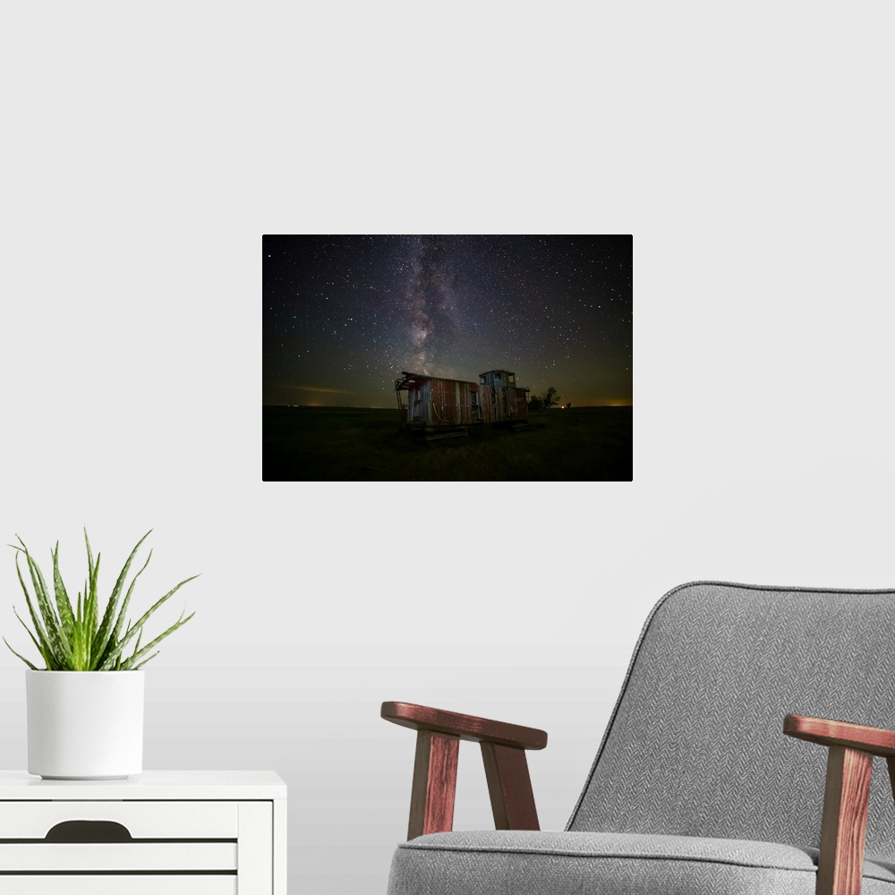 A modern room featuring Old caboose at nighttime under a bright, starry sky; Coderre, Saskatchewan, Canada