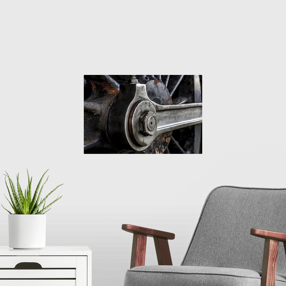 A modern room featuring A close-up photograph of the wheel of a train.