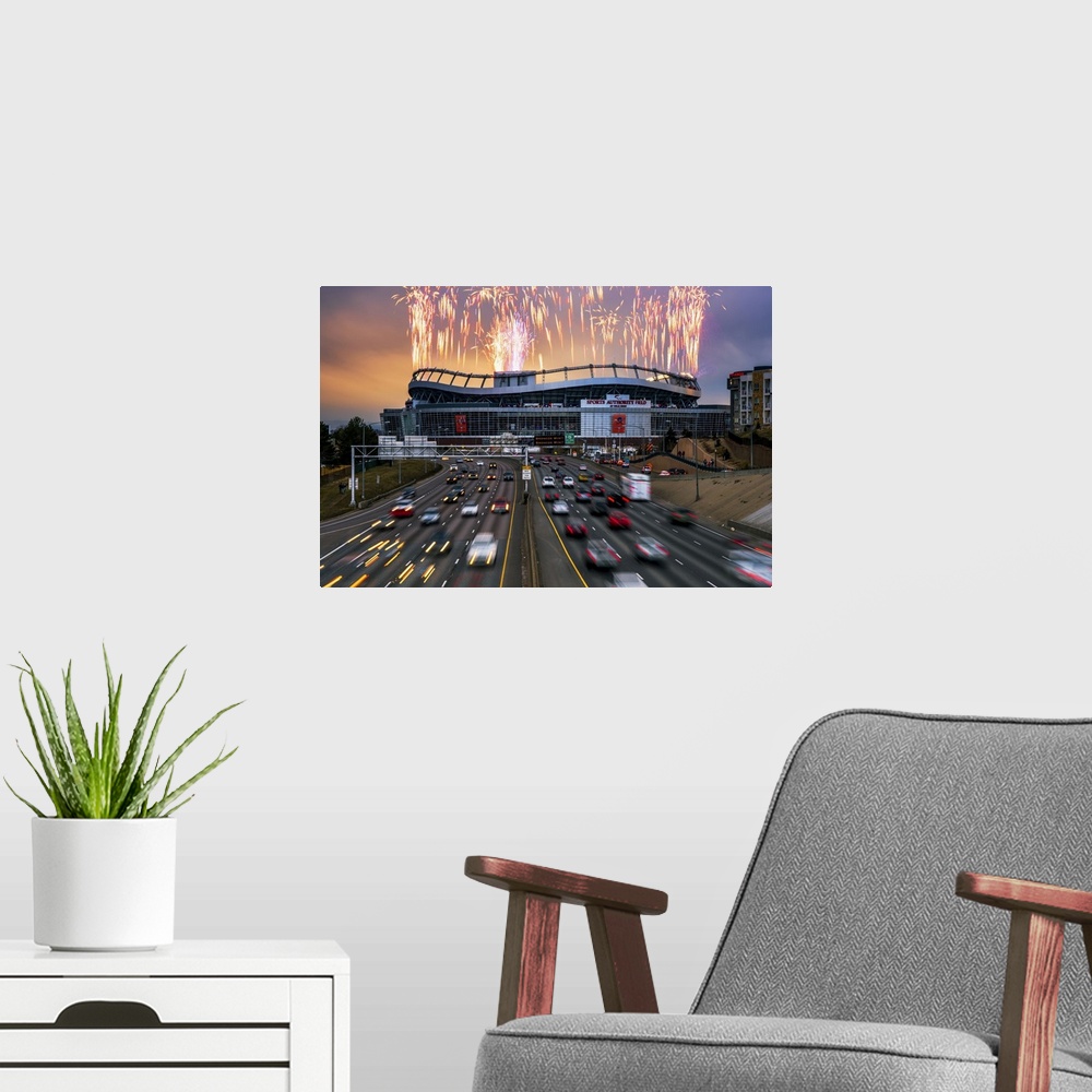 A modern room featuring Fireworks over a stadium seen from the highway.