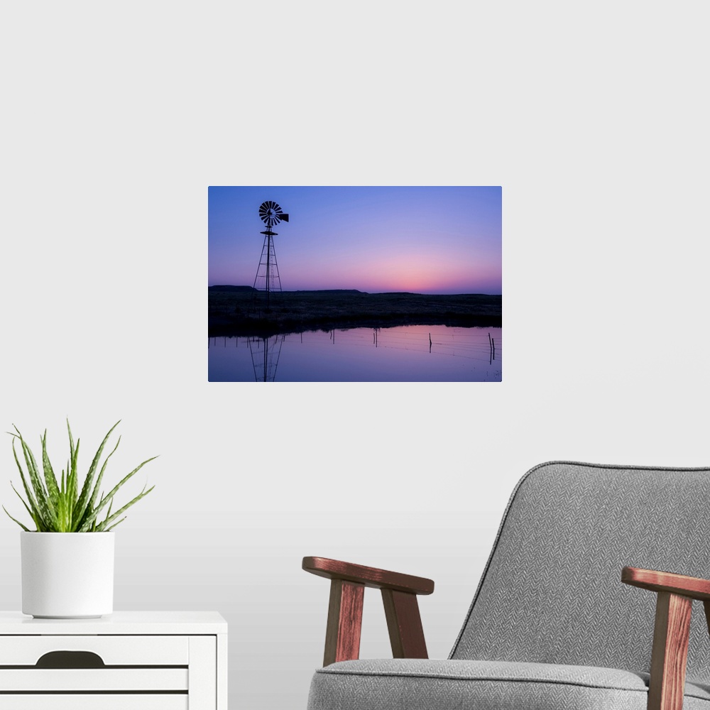 A modern room featuring windmill in by the water at sunset