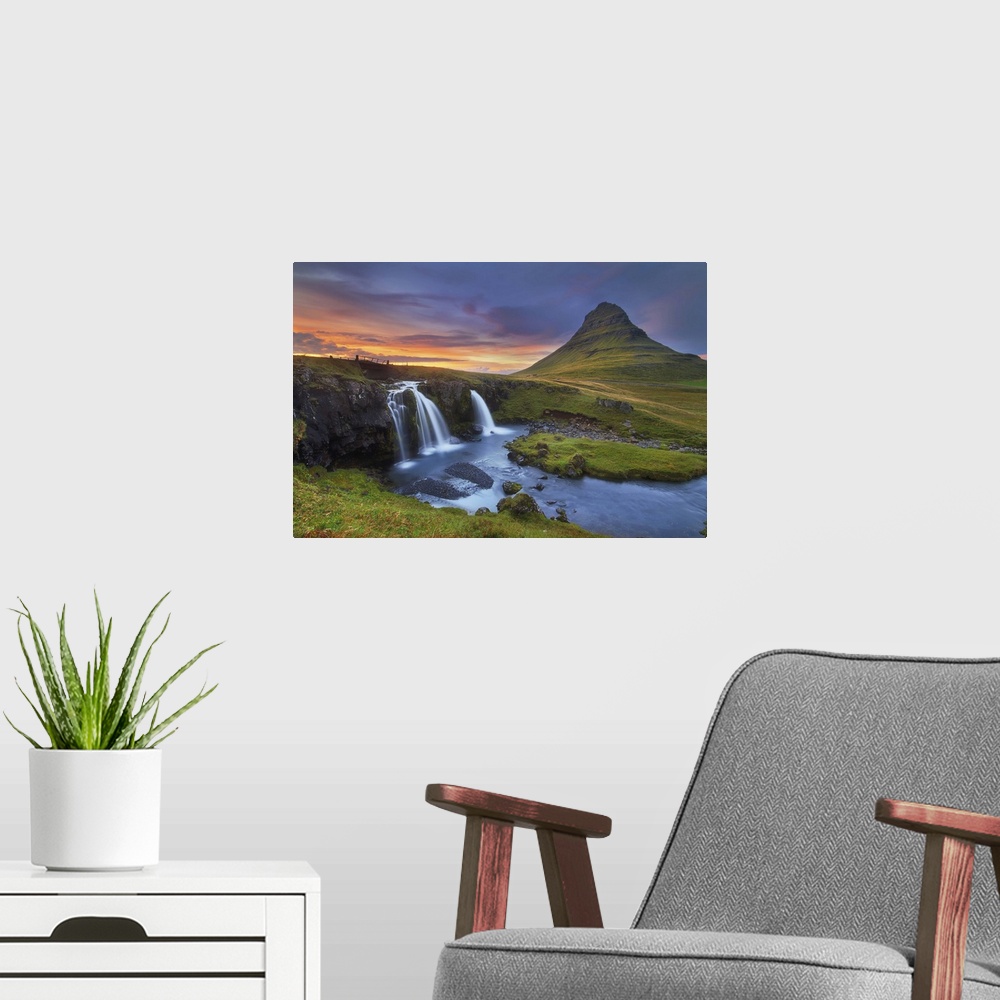 A modern room featuring A photograph of an Icelandic landscape with waterfalls to the left and a sunset cloudscape hangin...