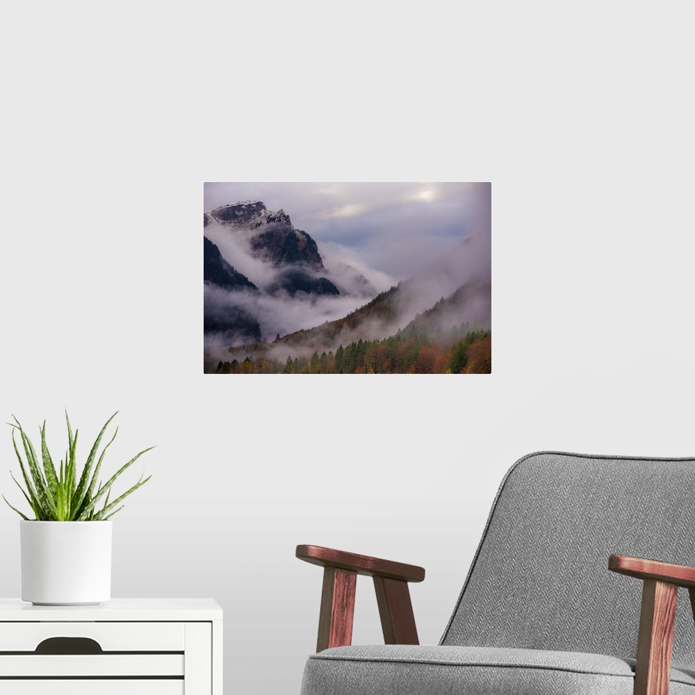 A modern room featuring A photograph of a mountain valley covered in deep with thick fog shrouding the area.