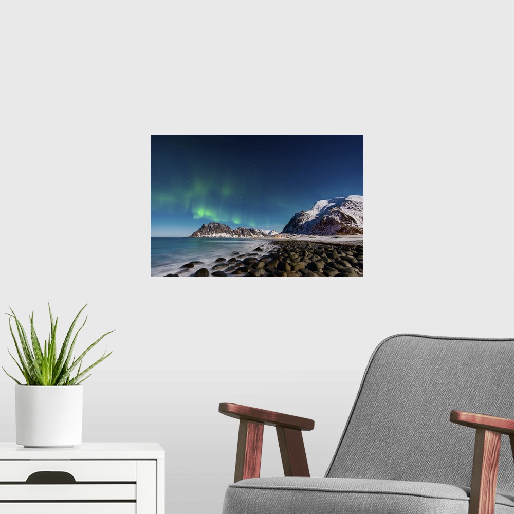 A modern room featuring A photograph of a snow covered mountain range under a night sky with northern lights above.